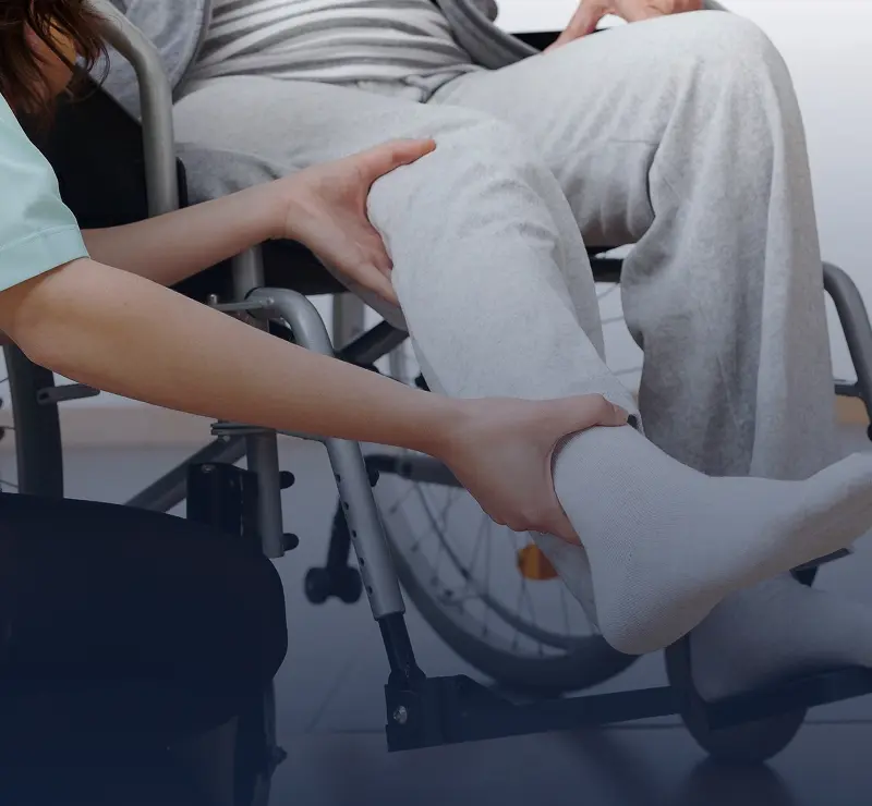 Caregiver assisting person in wheelchair transfer.